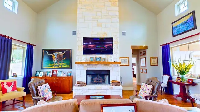 a living room with furniture fireplace and a large window