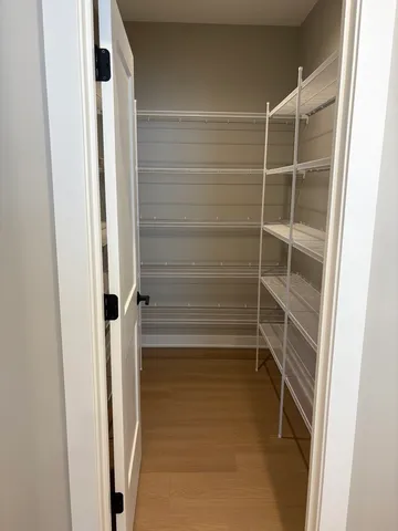 a view of walk in closet with empty racks