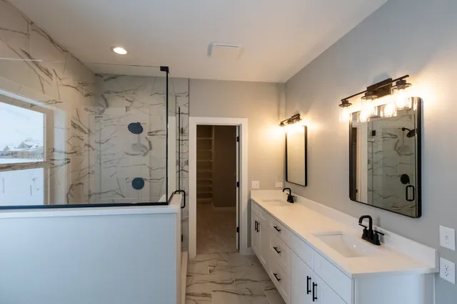 a bathroom with a double vanity sink mirror and shower