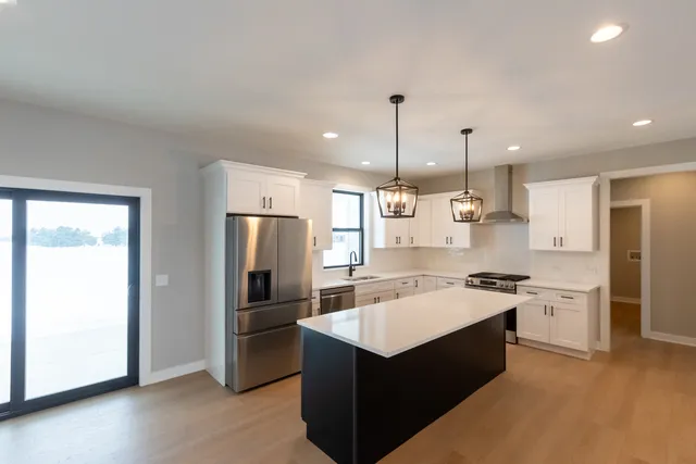 a kitchen with a refrigerator a sink and dishwasher with wooden floor