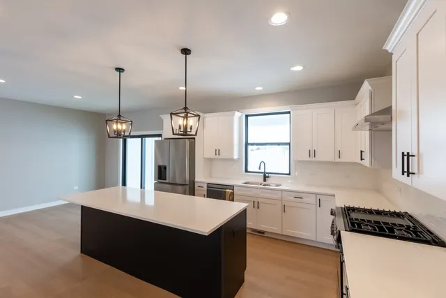 a kitchen with kitchen island a sink stainless steel appliances and cabinets