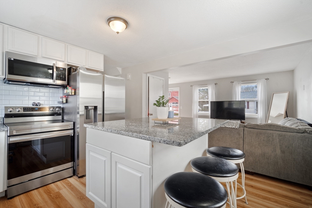 71 Price Street Springfield, MA 01104 - Photo 21 of 42 a kitchen with stainless steel appliances granite countertop a sink and a stove
