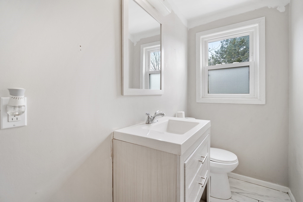 71 Price Street Springfield, MA 01104 - Photo 34 of 42 a bathroom with a toilet a sink and mirror