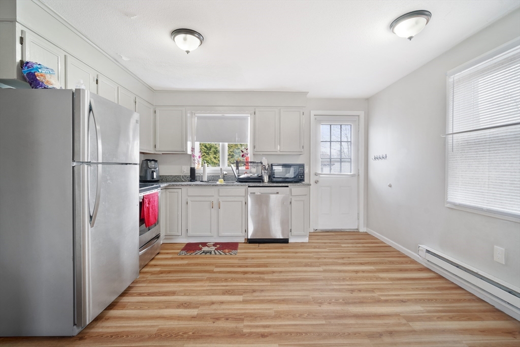 71 Price Street Springfield, MA 01104 - Photo 7 of 42 a kitchen with stainless steel appliances granite countertop a refrigerator sink and white cabinets