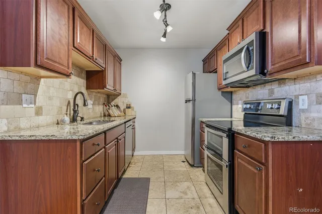 a kitchen with stainless steel appliances granite countertop a sink stove and cabinets