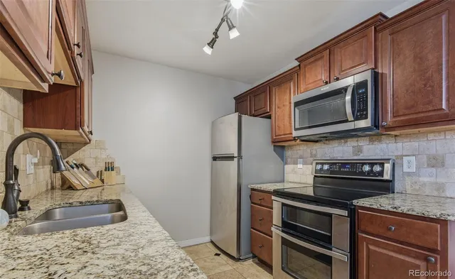 a kitchen with stainless steel appliances granite countertop a stove microwave and sink