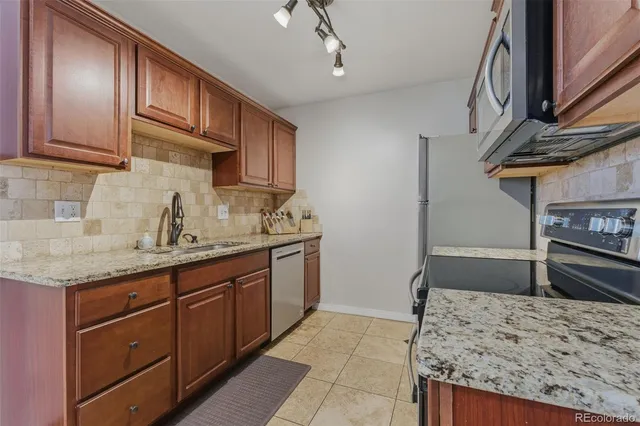 a kitchen with stainless steel appliances granite countertop a sink stove and refrigerator