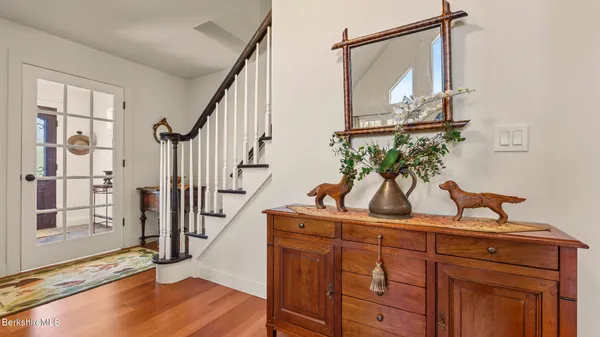a view of hallway with wooden floor and cabinet