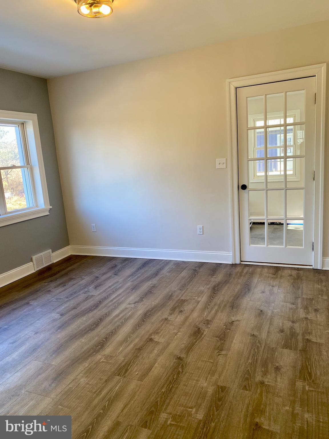 1297 Highway 40 Pilesgrove, NJ 08098 - Photo 11 of 32 an empty room with wooden floor and windows
