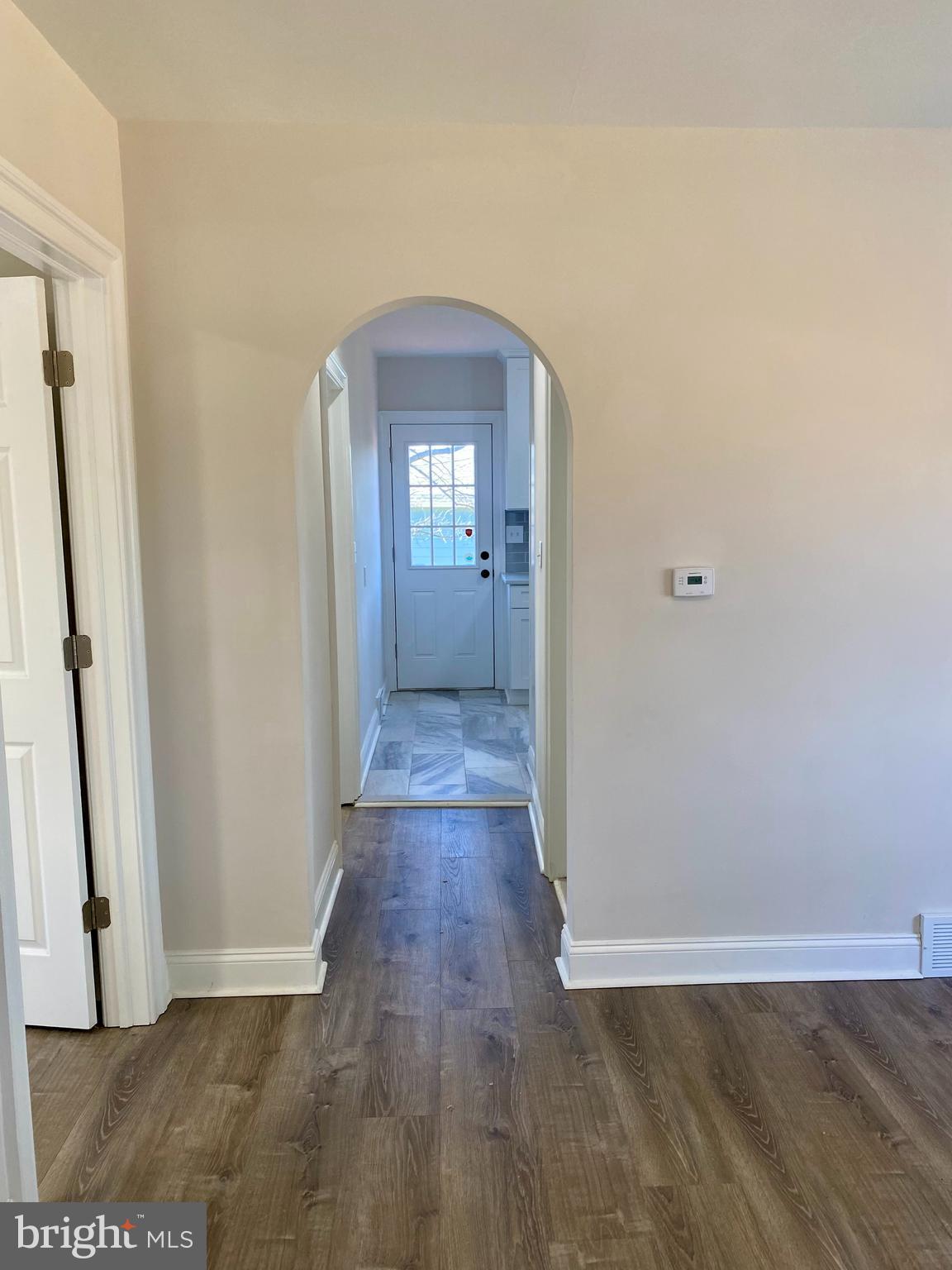 1297 Highway 40 Pilesgrove, NJ 08098 - Photo 17 of 32 an empty room with wooden floor and a hallway