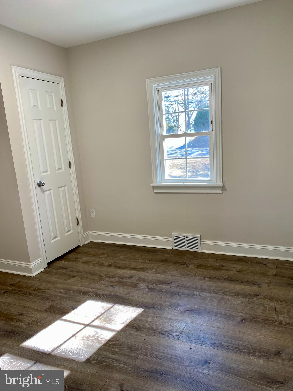 1297 Highway 40 Pilesgrove, NJ 08098 - Photo 19 of 32 a view of an empty room with wooden floor and a window