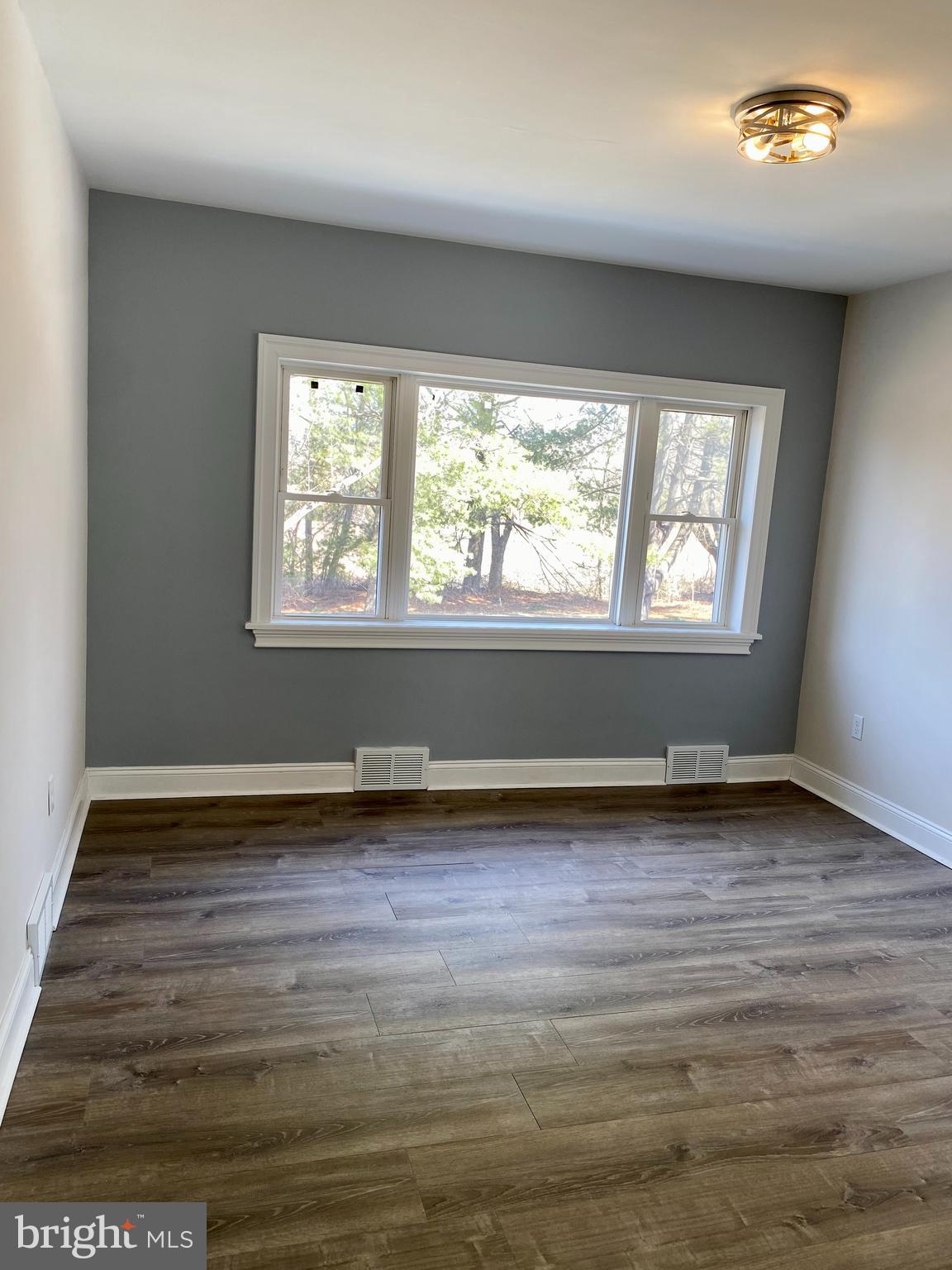 1297 Highway 40 Pilesgrove, NJ 08098 - Photo 9 of 32 an empty room with wooden floor and windows