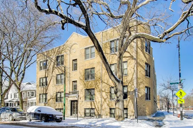 a front view of a building with large trees