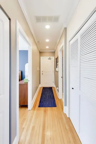 a view of a hallway with wooden floor and staircase