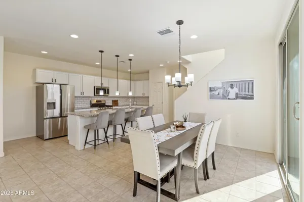 a dining room filled with furniture and kitchen view