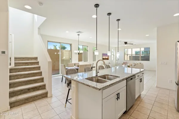 a kitchen with a sink a counter top space and a view of living room