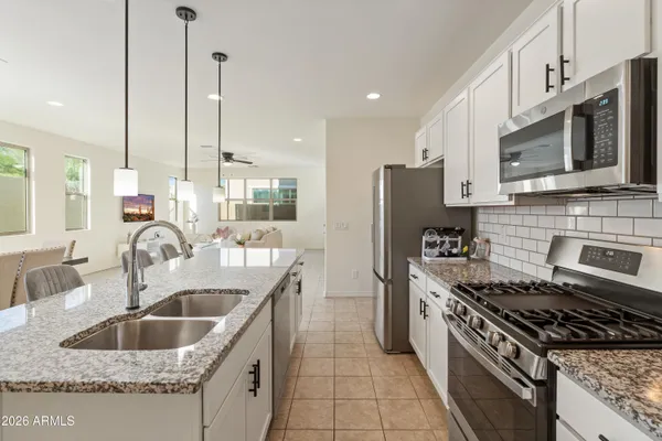 a kitchen with stainless steel appliances granite countertop a sink stove and refrigerator