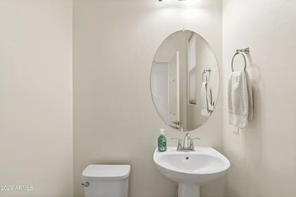 a bathroom with a sink a toilet and a mirror