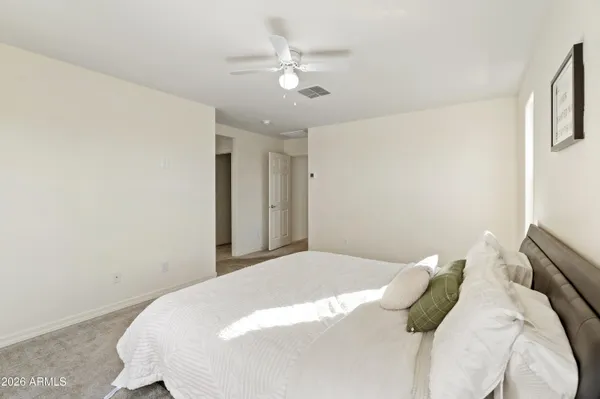 a bedroom with a bed and a ceiling fan