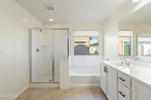 a bathroom with a tub sink and mirror