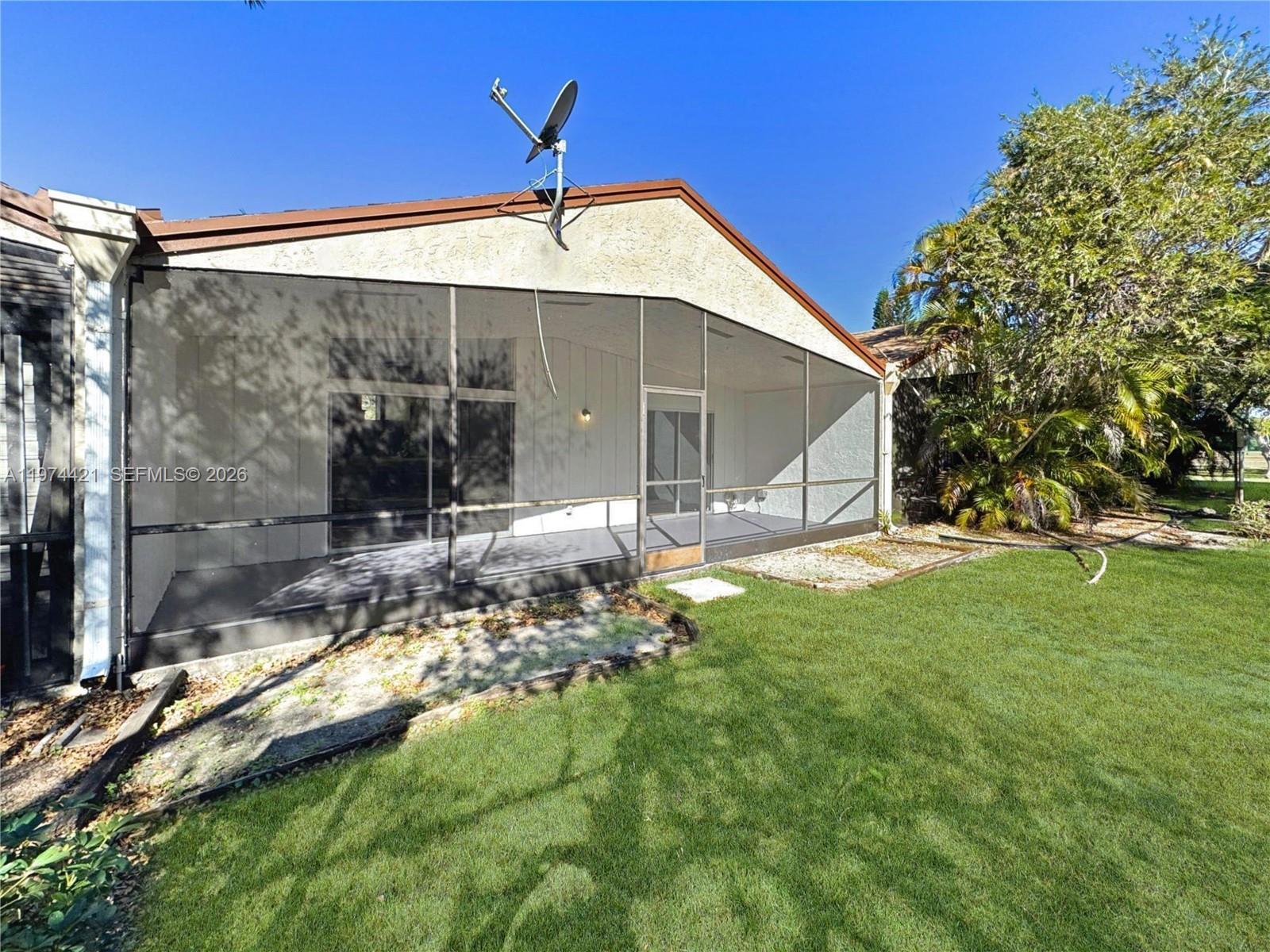 22278 Misty Woods Way Boca Raton, FL 33428 - Photo 14 of 20 a backyard of a house with table and chairs under an umbrella