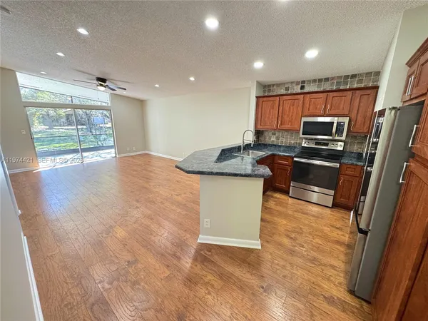 a kitchen with stainless steel appliances granite countertop a sink stove and refrigerator