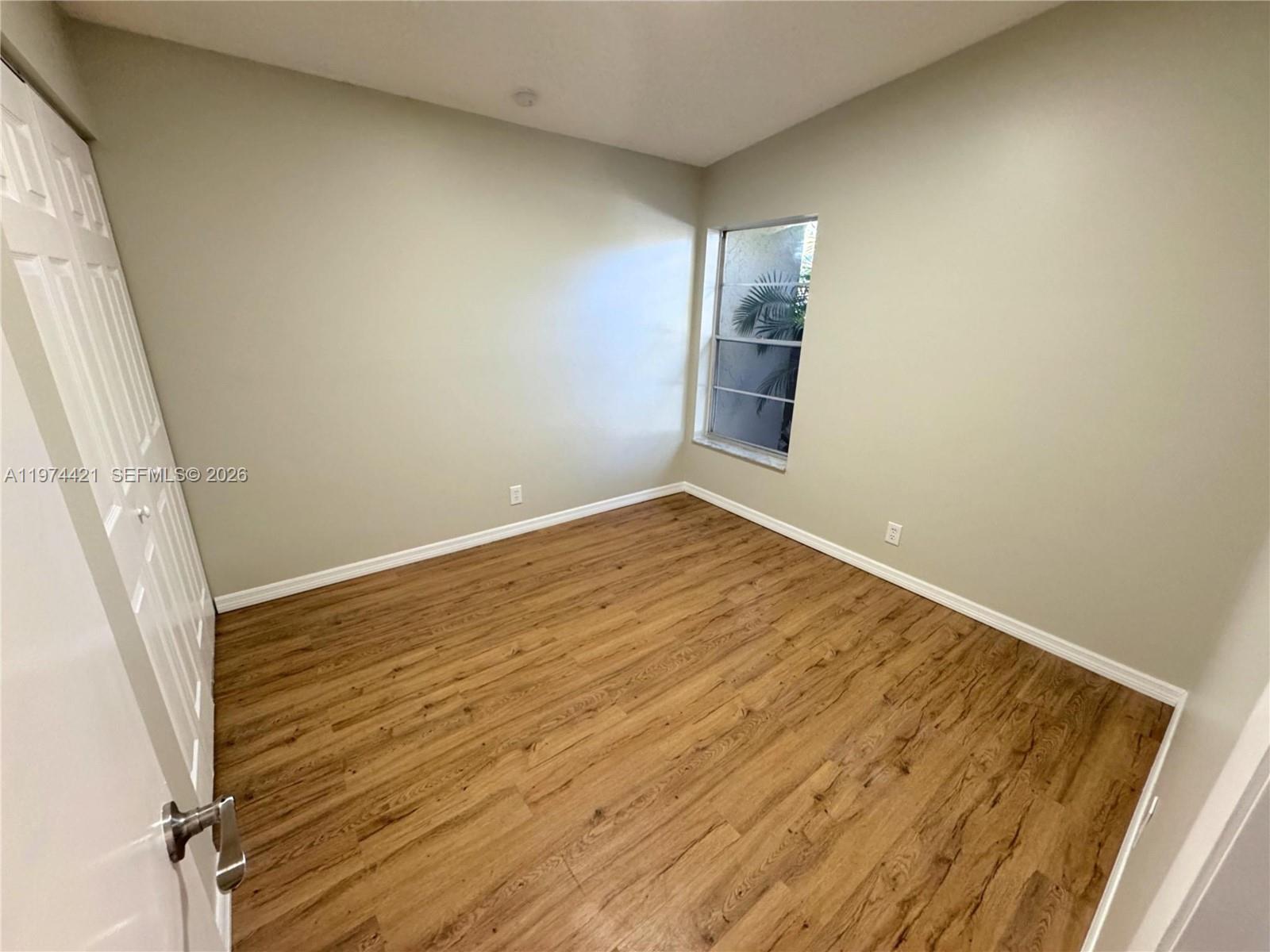 22278 Misty Woods Way Boca Raton, FL 33428 - Photo 8 of 20 an empty room with wooden floor and windows