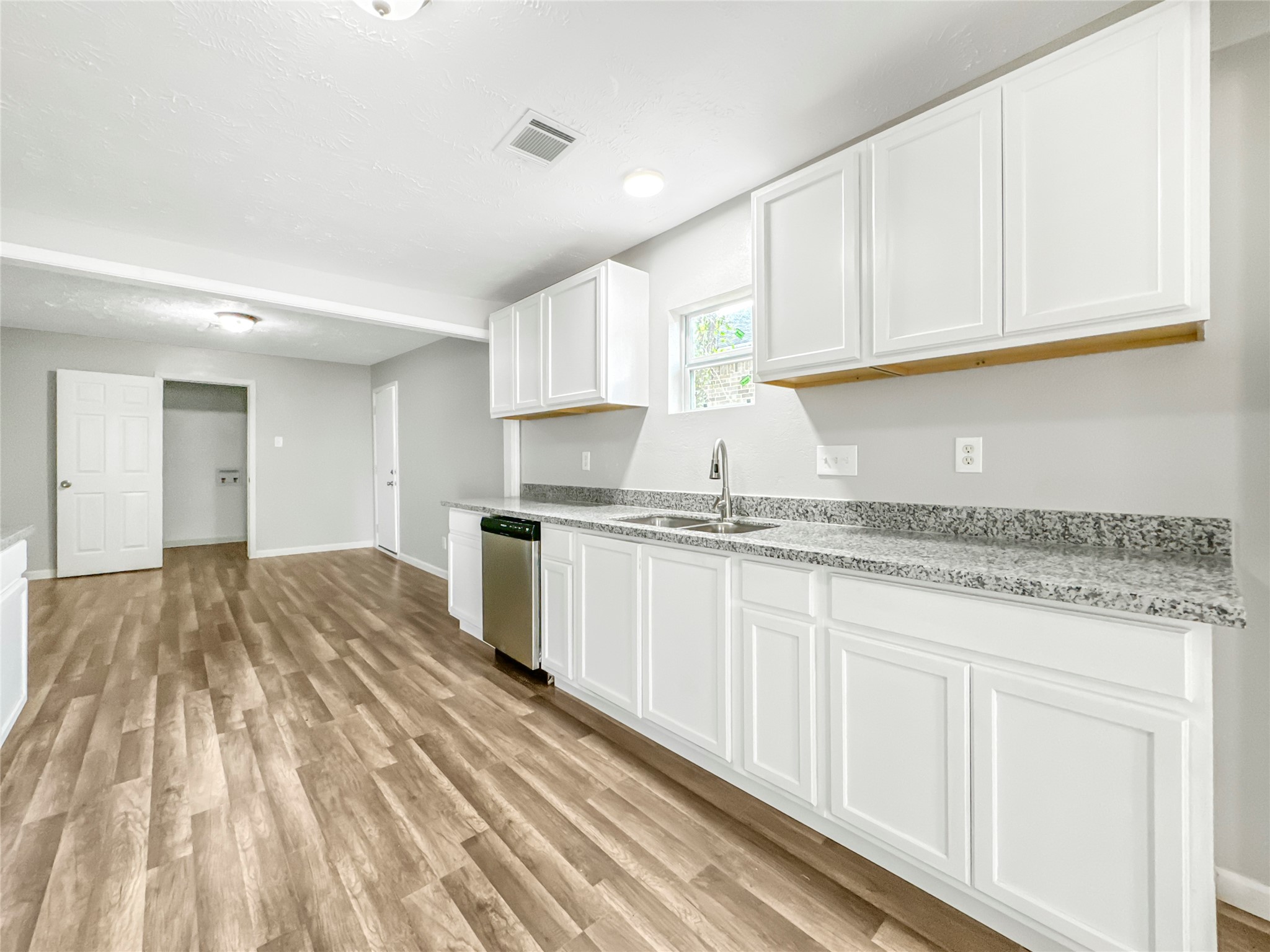 306 Armstrong Street Houston, TX 77029 - Photo 6 of 30 a kitchen with granite countertop white cabinets and stainless steel appliances