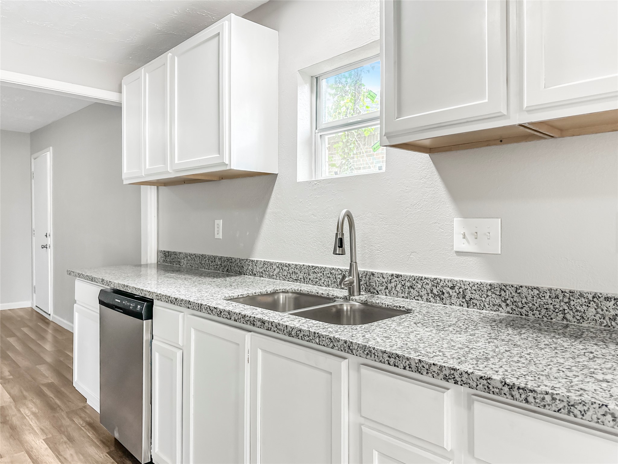 306 Armstrong Street Houston, TX 77029 - Photo 10 of 30 a kitchen with granite countertop a sink and white cabinets