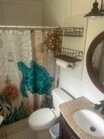 a bathroom with a granite countertop toilet sink and mirror