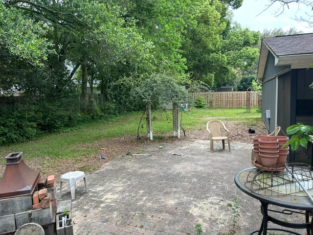 a view of a chair and table in backyard of the house