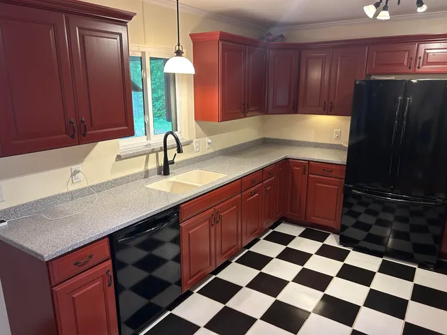a kitchen with a sink a refrigerator and cabinets