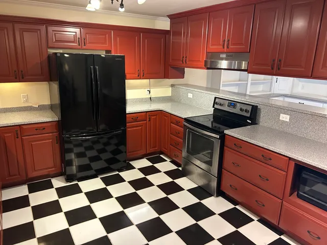 a kitchen with stainless steel appliances granite countertop a refrigerator and a stove