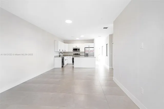 a kitchen that has a lot of cabinets and wooden floor