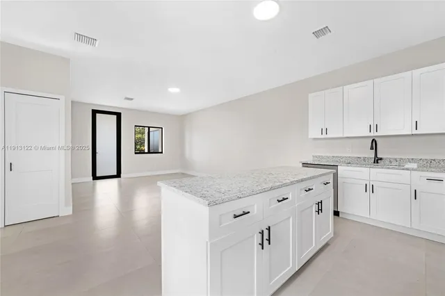 a kitchen with stainless steel appliances a sink a stove top oven a counter space and cabinets