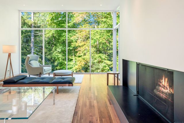 a view of a living room with a floor to ceiling window and wooden floor