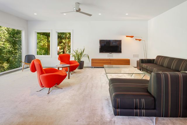 a living room with furniture a flat screen tv and a large window