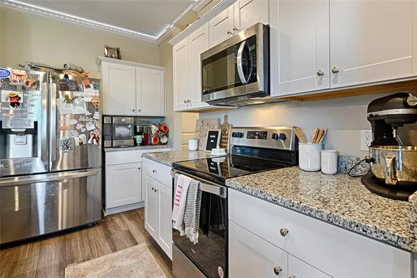 a kitchen with granite countertop stainless steel appliances and wooden cabinets