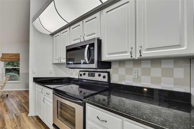 a bathroom with a granite countertop toilet sink and mirror
