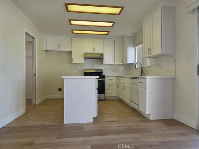 a kitchen with a sink cabinets stainless steel appliances and a window