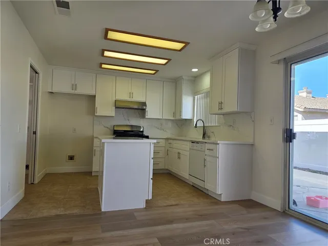 a kitchen with granite countertop white cabinets and black appliances