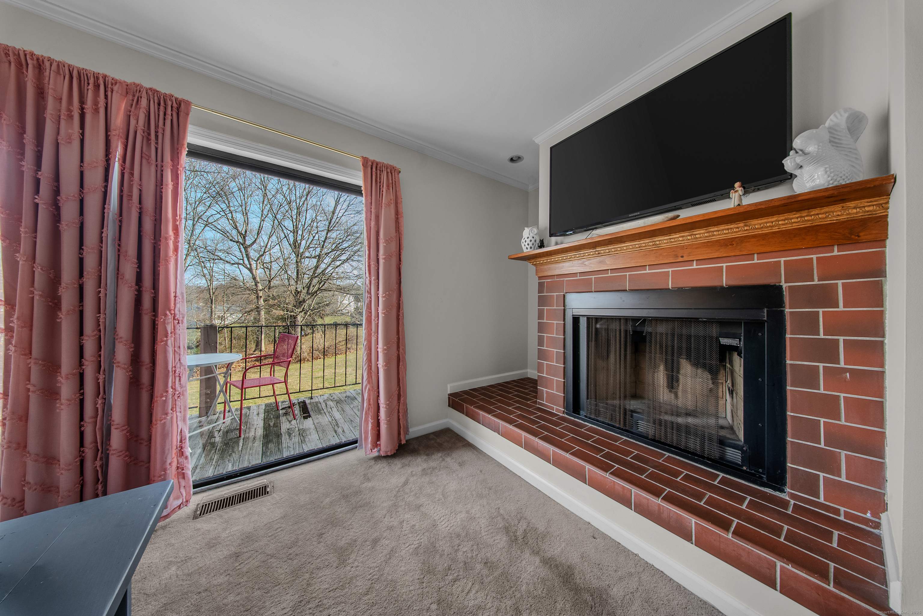 83 Carriage Drive, Unit 83 Milford, CT 06460 - Photo 14 of 33 a living room with a fireplace and a flat screen tv