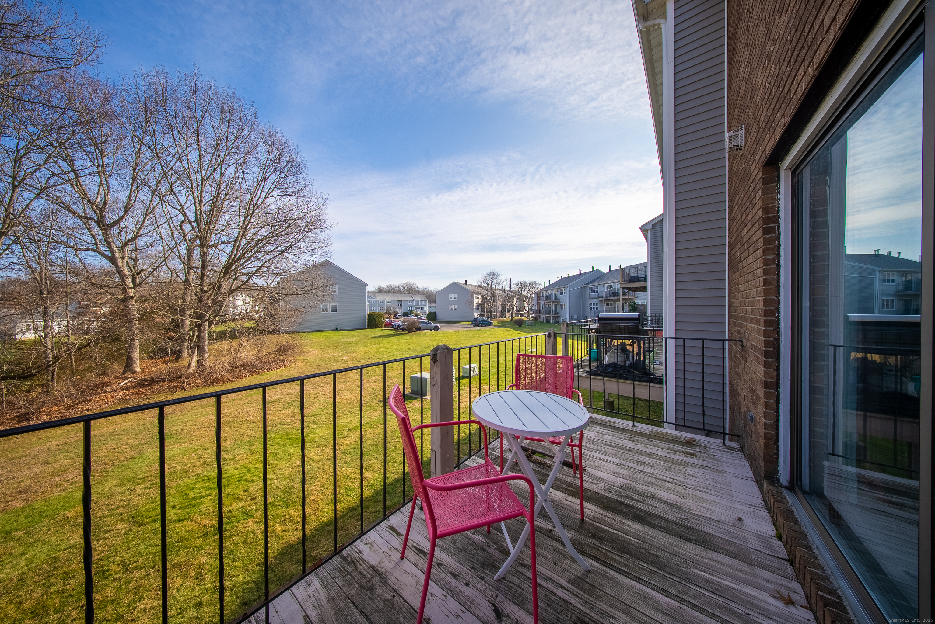 83 Carriage Drive, Unit 83 Milford, CT 06460 - Photo 15 of 33 a view of a balcony with chair and wooden floor