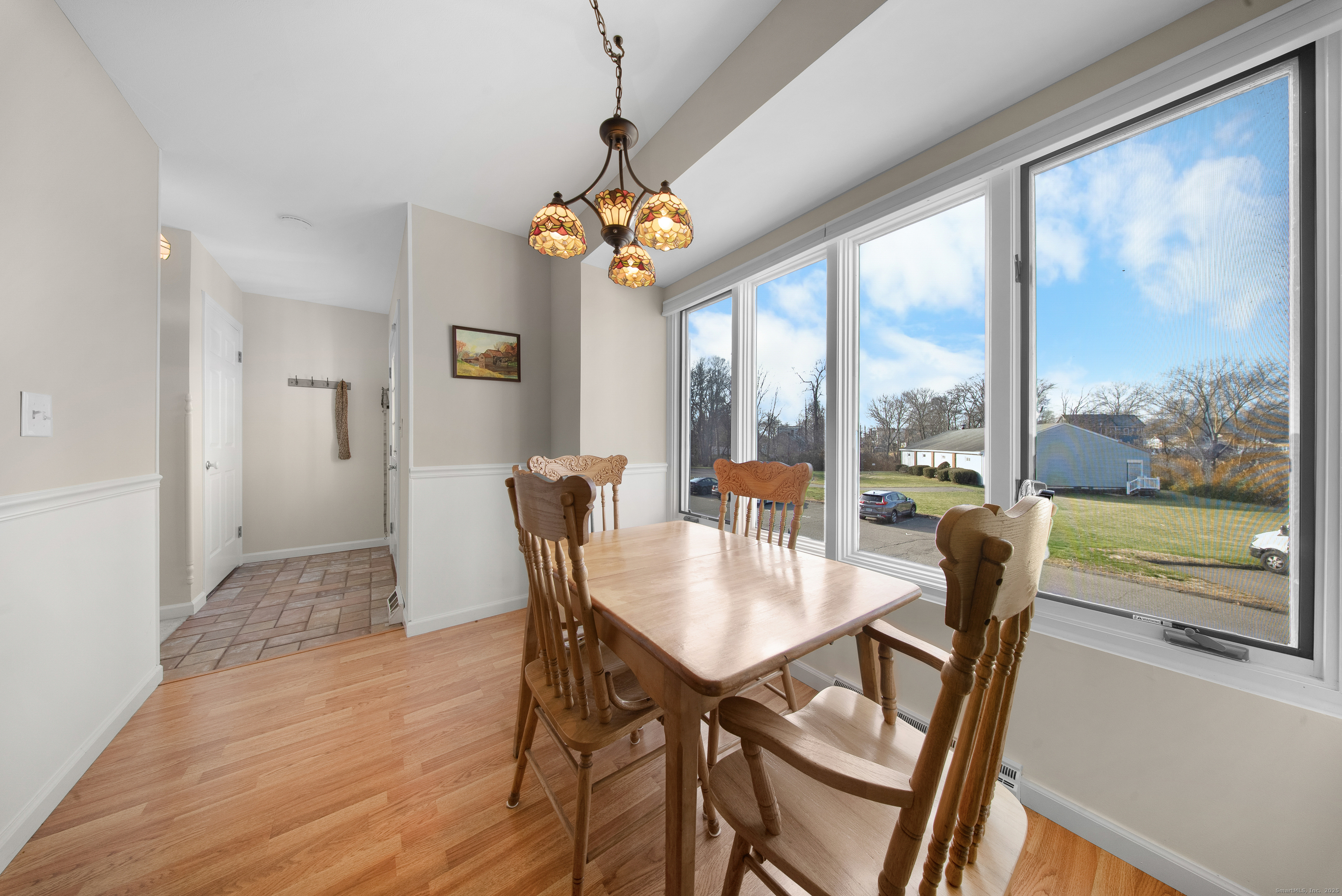 83 Carriage Drive, Unit 83 Milford, CT 06460 - Photo 4 of 33 a view of a dining room with furniture a chandelier and wooden floor