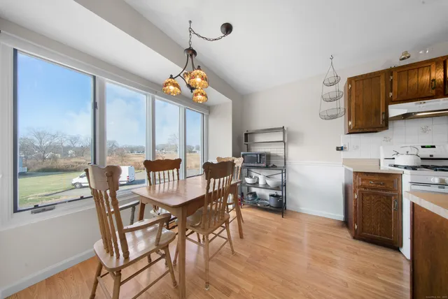 a view of a dining room with furniture a flat screen tv and wooden floor