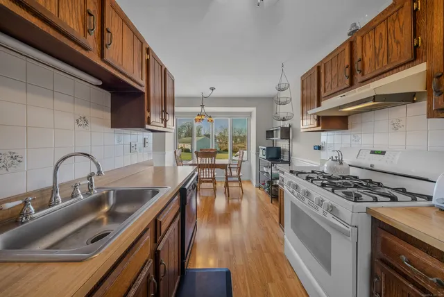 a kitchen with stainless steel appliances granite countertop a sink stove and cabinets