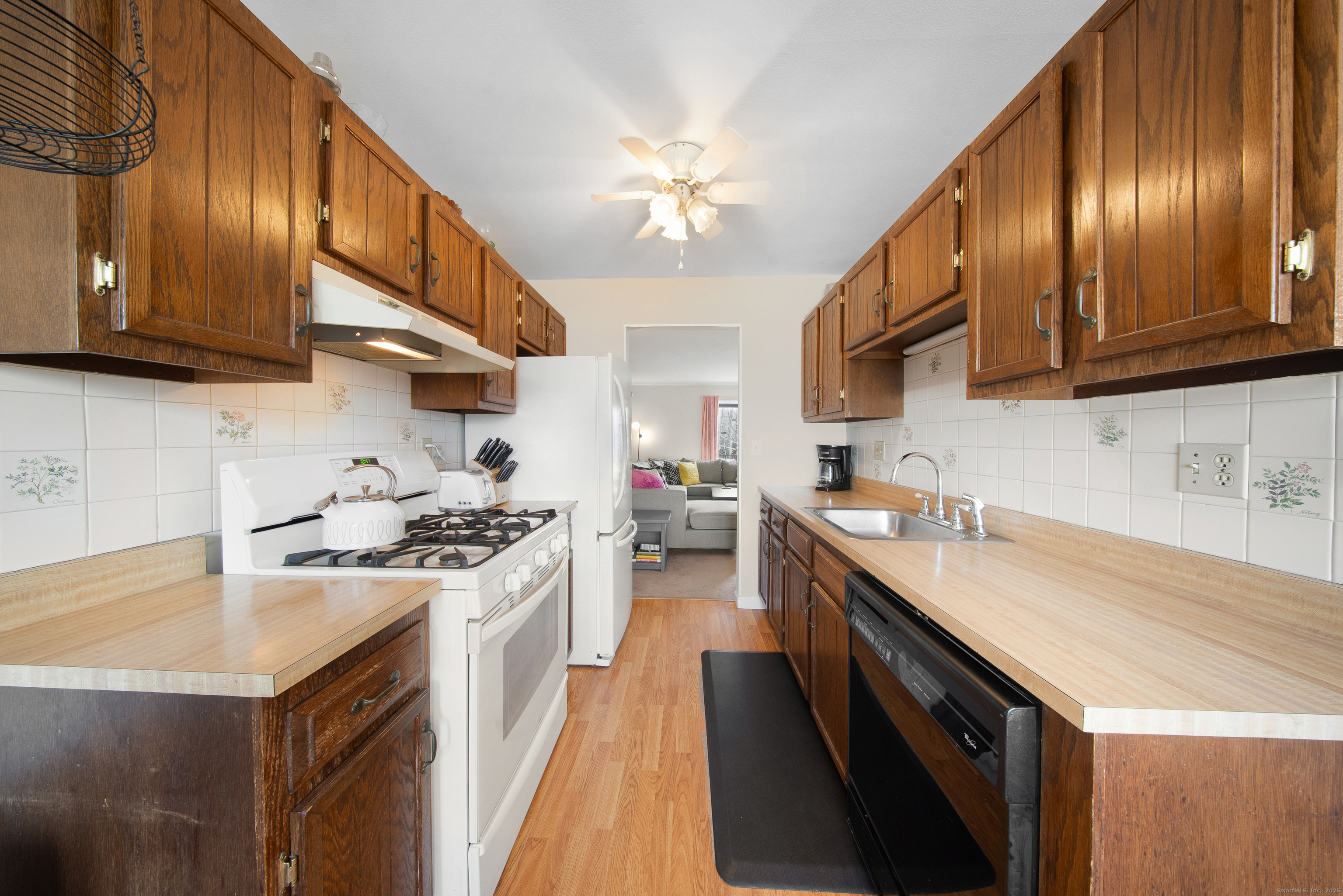 83 Carriage Drive, Unit 83 Milford, CT 06460 - Photo 9 of 33 a kitchen with a stove sink and cabinets