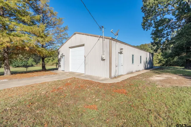 a view of a house with backyard and trees