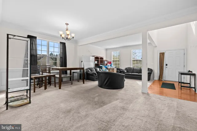 a living room with furniture a dining table and a chandelier