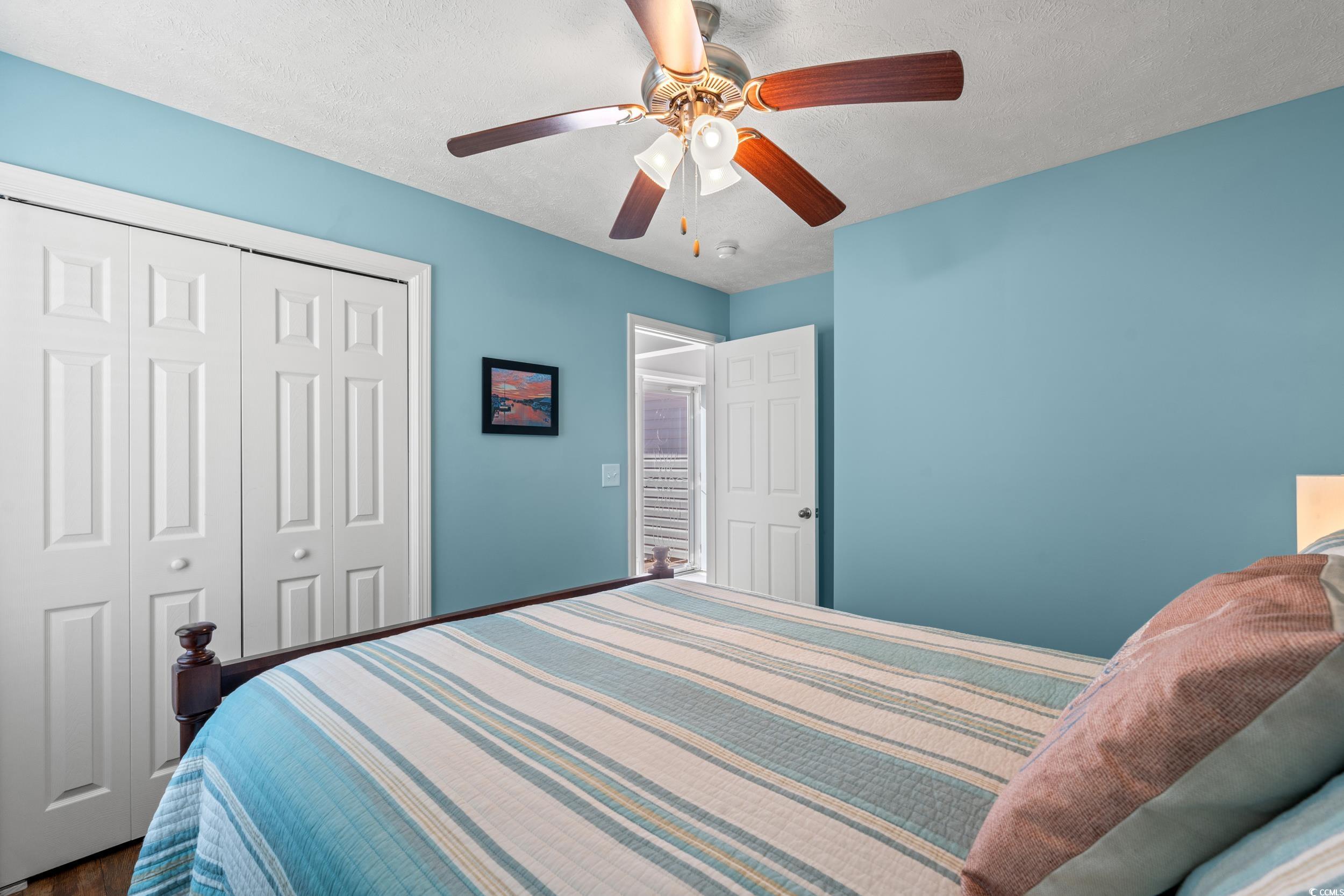 166 Woodland Park Loop Murrells Inlet, SC 29576 - Photo 20 of 39 Bedroom with ceiling fan, a closet, and a textured